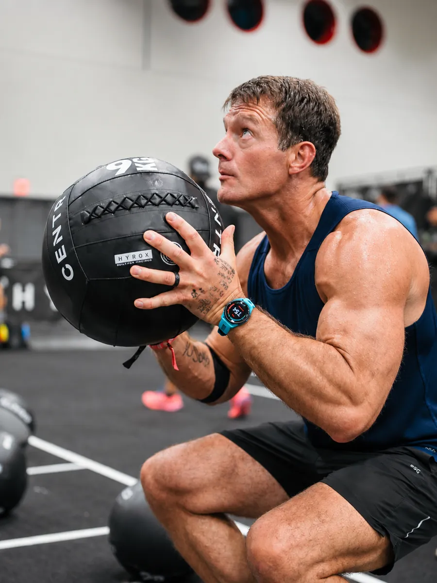 Athlete performing wall balls with a Hyrox medicine ball at True Grit Fitness