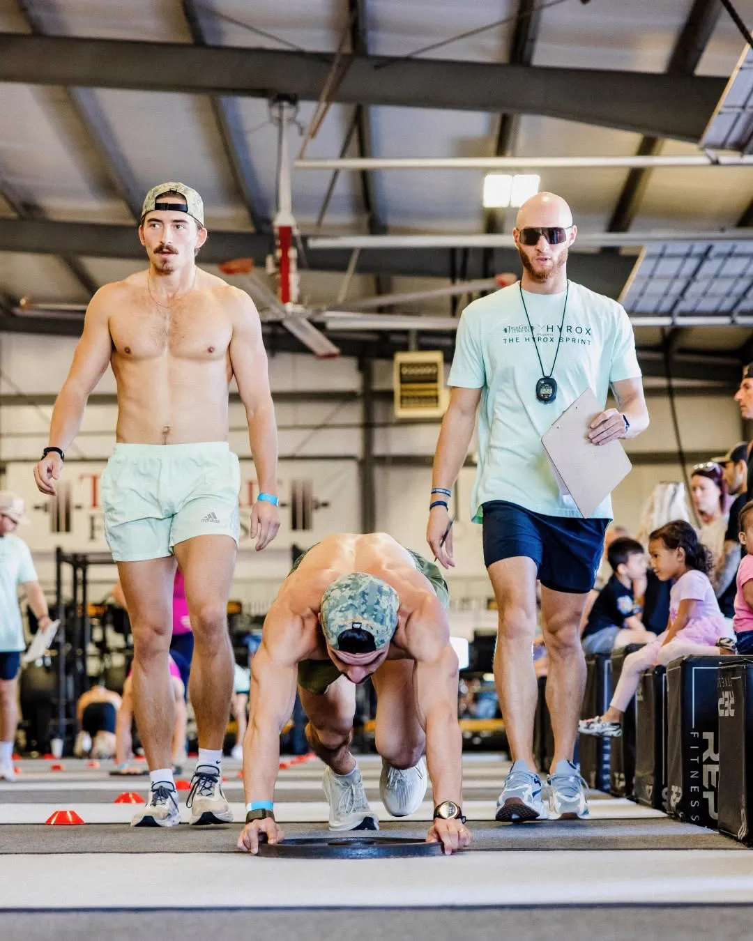 Athletes competing in a Hyrox Sprint burpee broad jump at True Grit Fitness in Edmond, Oklahoma